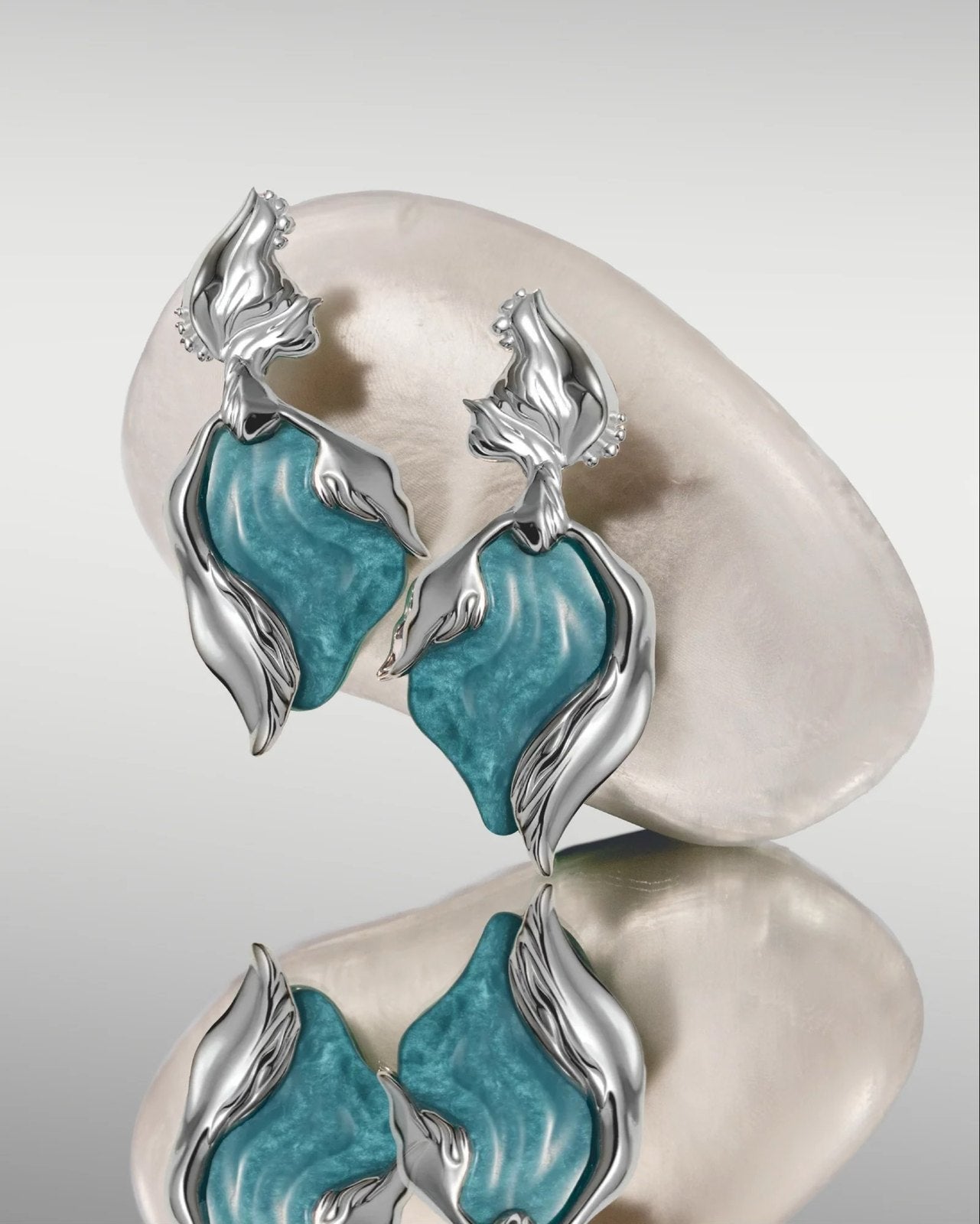 Silver earrings with teal resin stones on mother-of-pearl