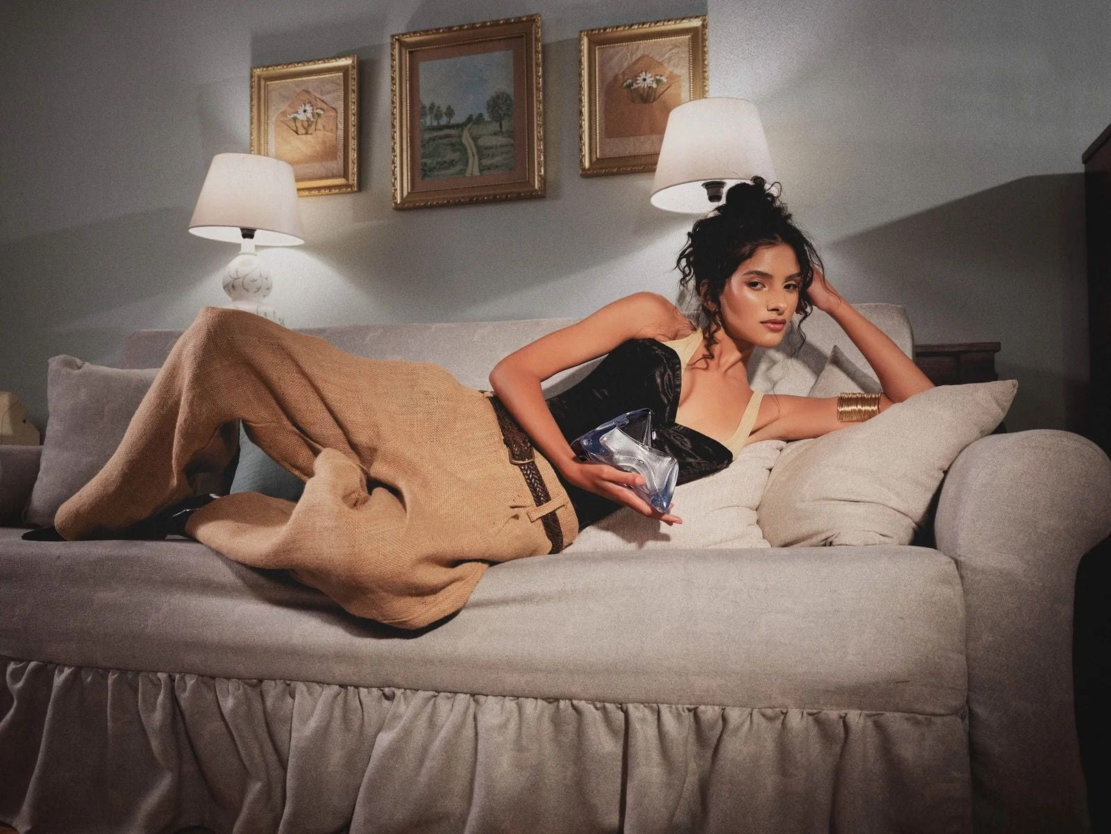 Reclining on a vintage sofa in burlap skirt with a glass clutch