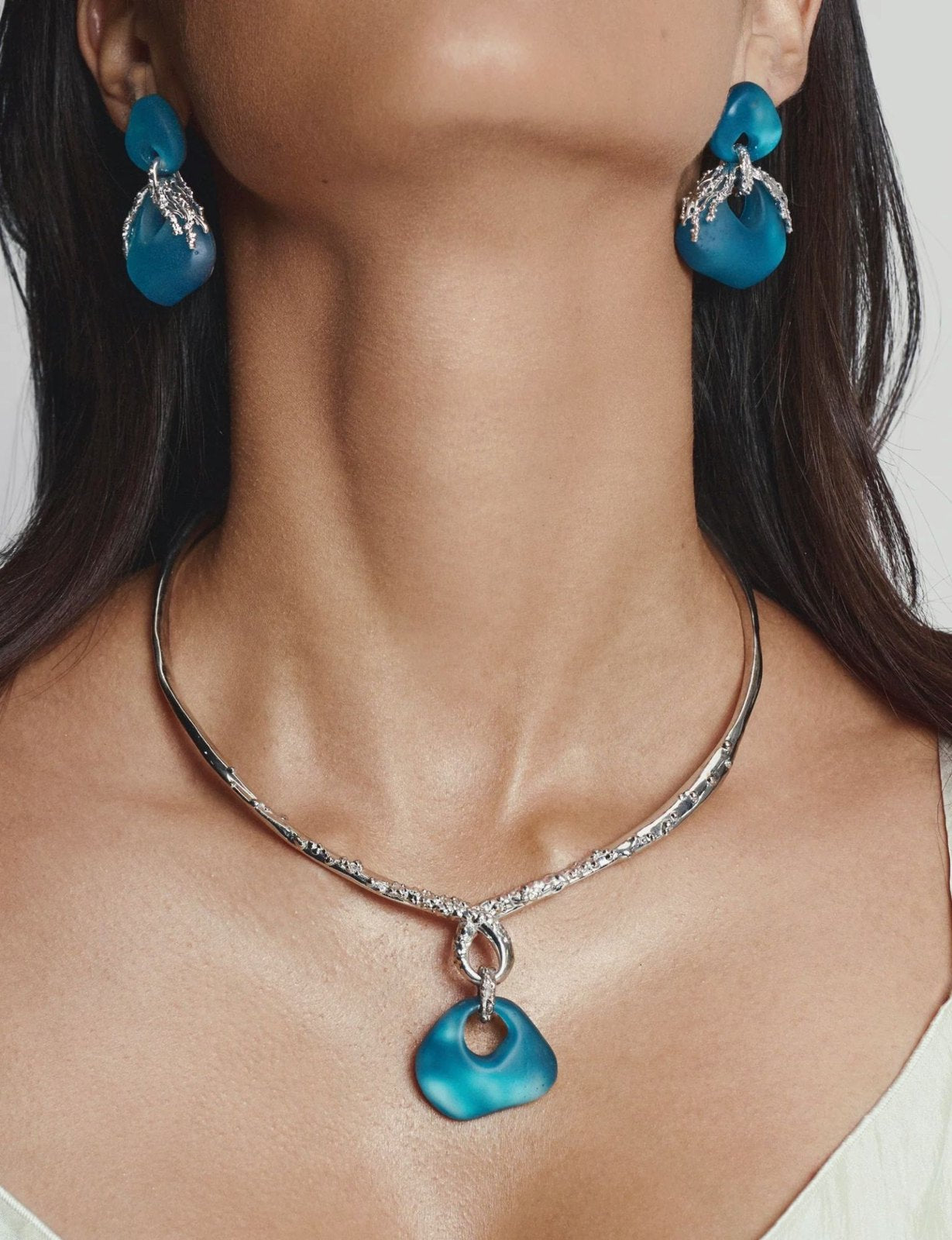 Jude Benhalim teal resin earrings and silver collar necklace, worn