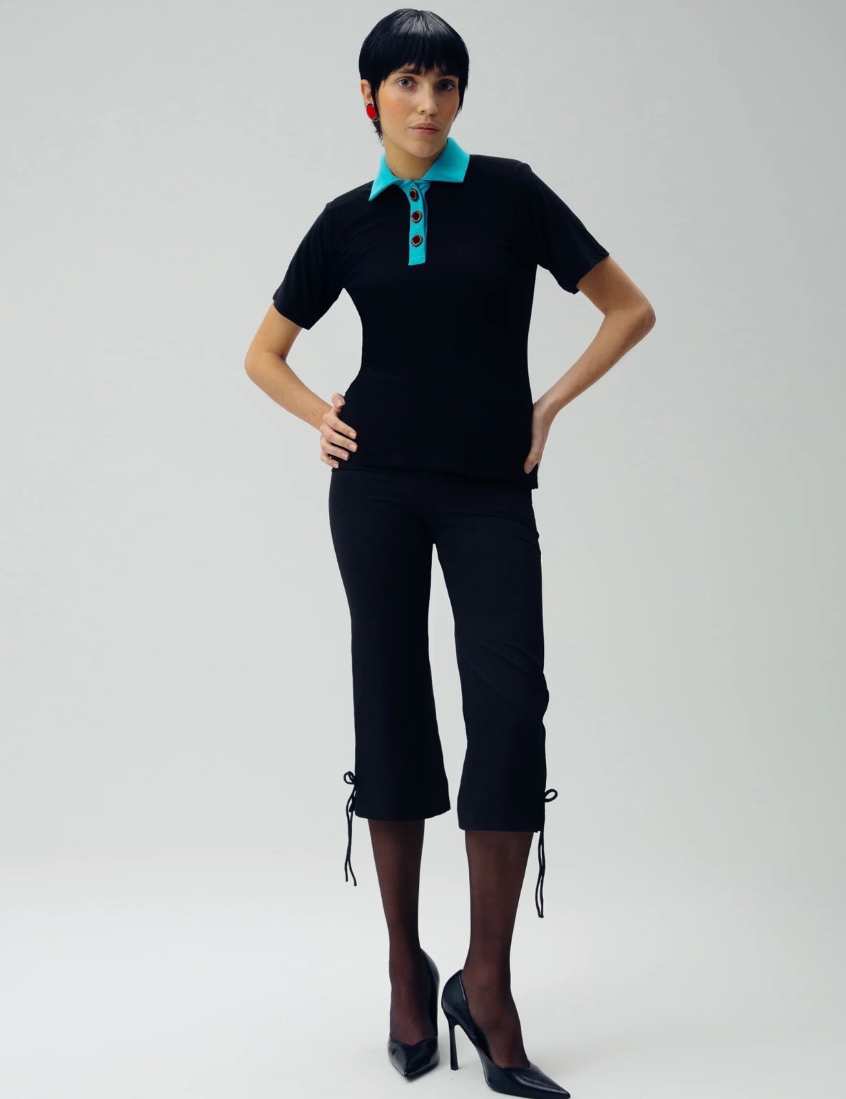 Womens — black polo with teal collar and cropped trousers, studio look