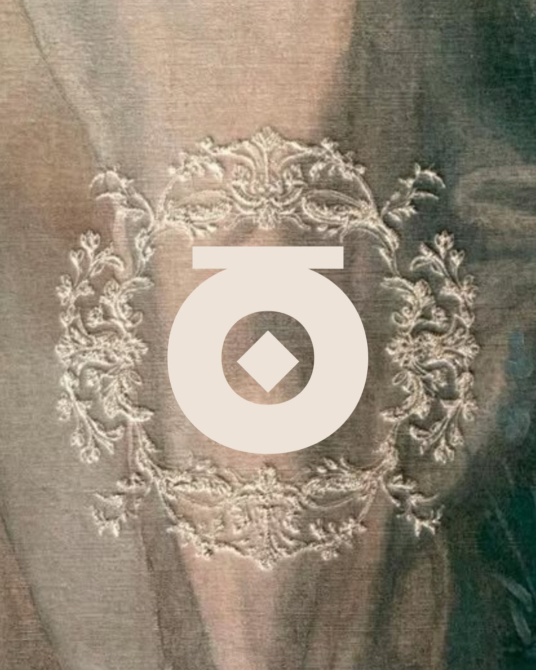 The House of Mena monogram in cream over an embroidered cartouche on antique fabric